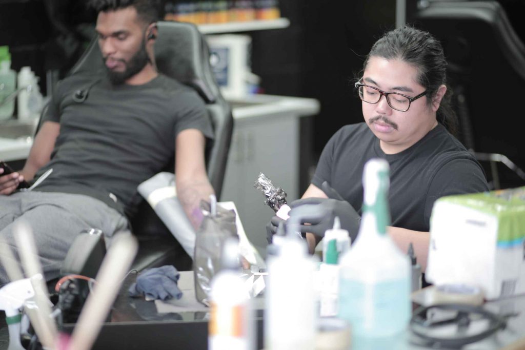 Francis working on a tattoo